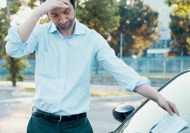 Homme déçu qui trouve un PV sur le pare-brise de sa voiture
